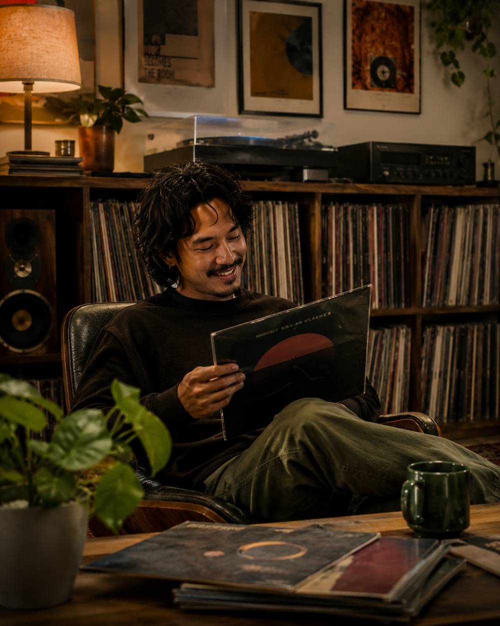 A collector relaxing at home beside a turntable and a wall of records